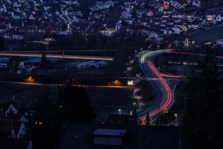 Road with light trails in blue hour with cityscapeの写真素材