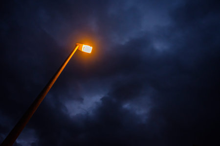 Yellow light of street lamp with cloudy sky in dawn