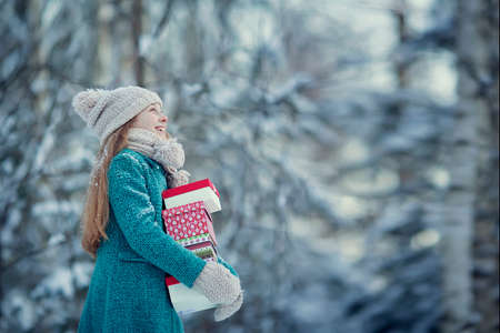 Girl with Christmas gift on a winter walkの写真素材