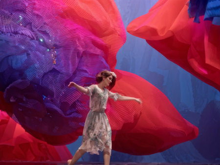 Dynamic Dance of Colorful Patterns A Womans Vibrant Movement Amidst Intricate Fabric Wondersの素材