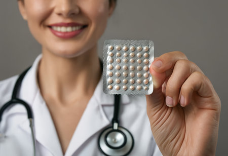 Close-up of a smiling female doctor holding a pack of pillsの素材