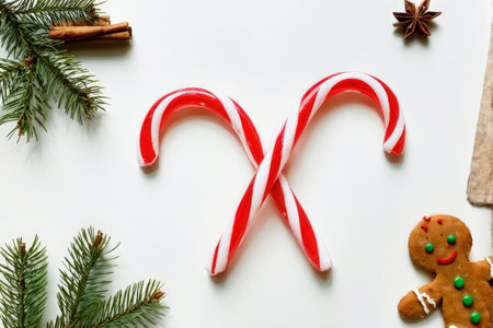 Christmas Decorations Arranged in Symmetrical X Shape Red Candy Canes Interweaving with Green Pine Branches, Cinnamon Sticks, Star Anise Spice, Gingerbread Man Cookie, and Cranberrの素材