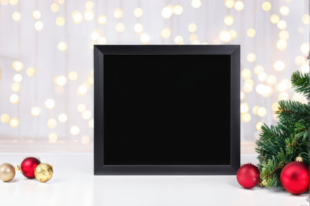 A framed mirror set against a festive Christmas background with ornaments and lightsの素材