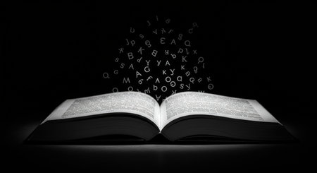 An open book with letters emanating from it in a dark settingの素材