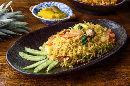 Pineapple fried rice served in a bowl on a wooden tableの写真素材