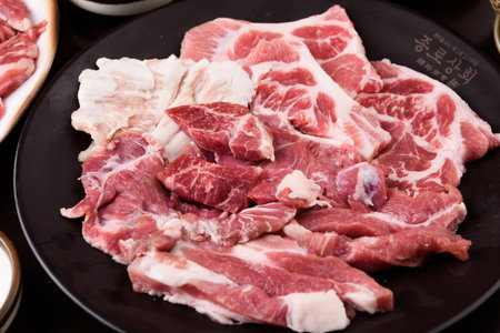 Raw pork on a black plate. Shabu shabuの写真素材
