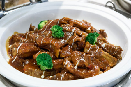 Beef stewed in sweet and sour sauce on a white plate