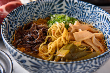 Noodles with beef and vegetables in a bowl on the tableの写真素材