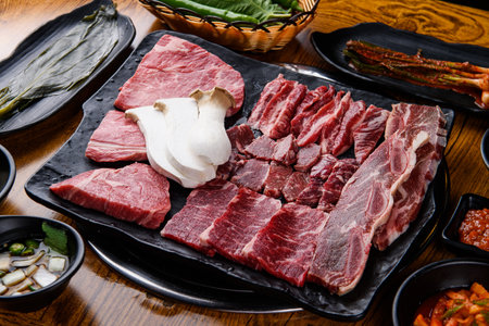 Korean barbecue, sliced beef and vegetables on wooden tableの写真素材