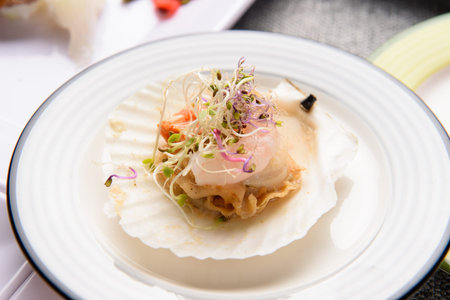 Steamed scallop and salad on a white plate