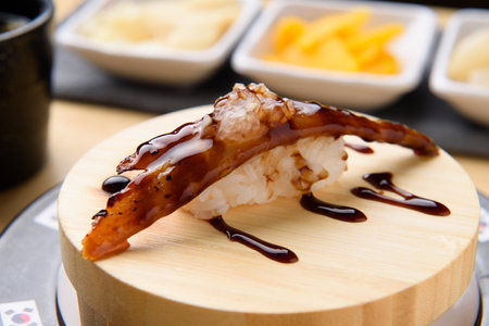japanese cuisine, eel sushi on wooden plate with chopsticksの写真素材