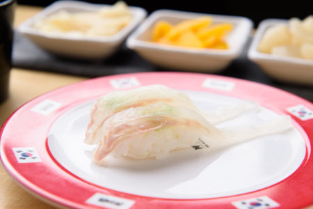 Sushi with wasabi and ginger on a plate in a restaurantの写真素材