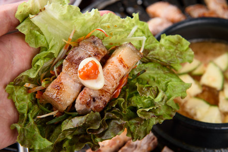 Grilled pork belly with vegetables on the grill, close-upの写真素材