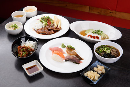 Japanese dining set featuring sushi, side dishes, and various accommodations.の写真素材