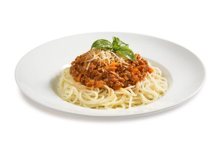 pasta bolognese  with basil on a plate on a white backgroundの写真素材