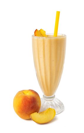 Peach smoothies in a glass with fresh fruits on a white backgroundの写真素材