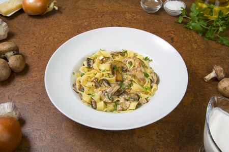 Fettuccine alfredo with mushrooms on an brown table. Selected focus.の写真素材
