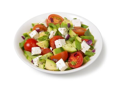 Salad with tomato, avocado, cucumber and  feta cheese in a white bowl isolated on white background.の写真素材