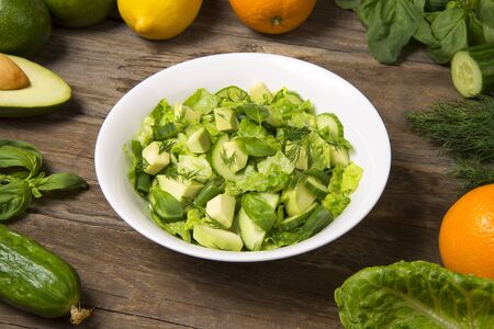 Salad with citrus vinaigrette, avocado cucumber green beans and romaine salad in an bowl on a rustic wooden table. Selected focus.の写真素材