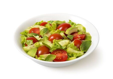 Salad with tomato, avocado, cucumber, lettuce, and basil in a white bowl isolated on white background.の写真素材