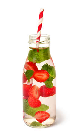 Cold fresh detox beverage of strawberry and mint leaves with water in glass bottle, isolated on white backgroundの写真素材