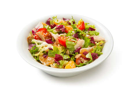 Salad with chicken, tangerines and vegetables in a white bowl isolated on white background. Close up.の写真素材