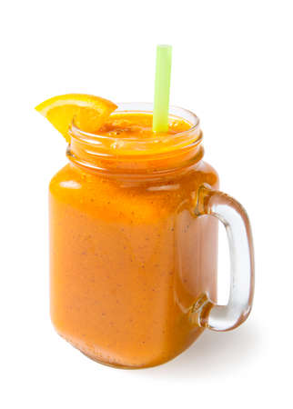 Mango orange banana and kiwi smoothie in a glass jar with an orange slice. Isolated on a white background.の写真素材