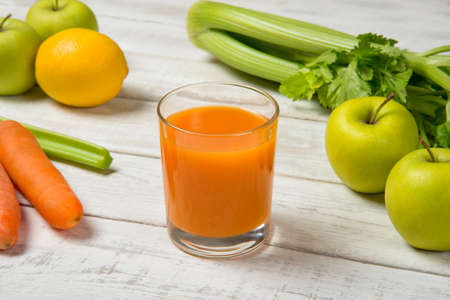 Carrot apple and celery juice on a white old table with ingredients. selected focus.の写真素材