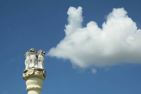 Stone lion on top of pillars and white clouds and blue skyの写真素材