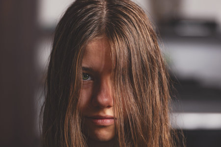 portrait of a girl with green eyes at home. Girl sitting in front of a living wall in the living...