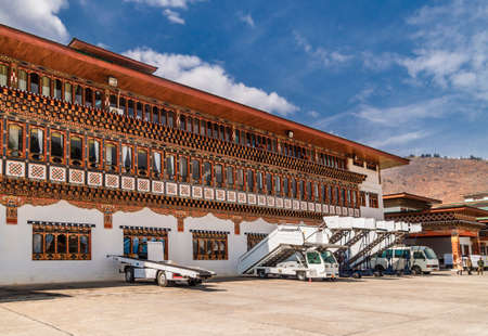 Paro/ Bhutan - February 26, 2016: the building of Paro Airport in traditional bhutan architecture style in Bhutan/ It is one of the most challenging airport, only few pilots are certified to land there. Belt loaders and gangway vehicle.のeditorial素材