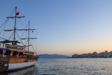 Vintage mast wooden sailing ship for sea tours in port of Saranda, Albania on sunset or sunrise. Sea landscape. Copy space for text.の写真素材