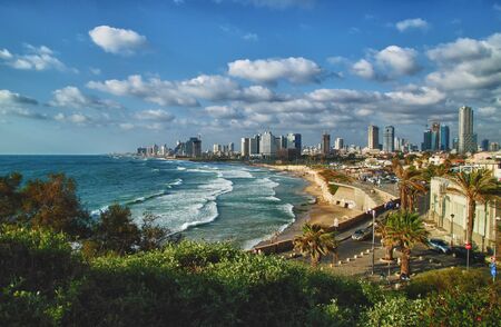 Panoramic view of modern Tel Aviv sky line and beach on sunny day. Mediterranean sea, Israel. Sea waves and cloudy sky.の写真素材
