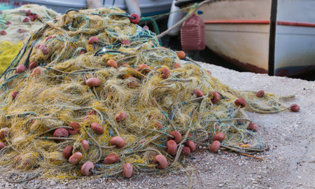 Traditional fishing net with floats on the shore after fishing on the background of boats.