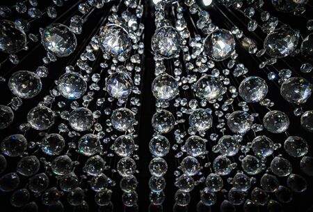 Abstract crystal chandelier pendant or crystal faceted balls background on blackの写真素材