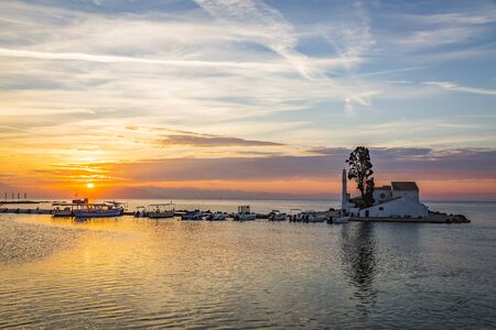 Early morning sunrise view of famous Vlachern? monastery, Pontikonissi or mouse island and fisherman boats in Halikiopoulou lagoon. Kanoni, Corfu island, Greece.の写真素材