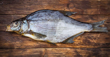 One dried salted fish bream on a wooden table, vintage style, top viewの写真素材