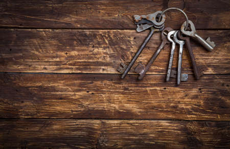Bunch of old vintage keys on wooden background, top view with space for text. Safety and security concept, copy spaceの写真素材