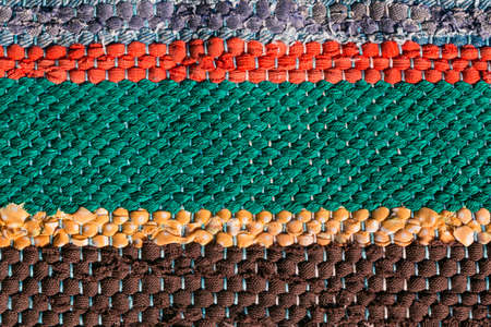 Close up of a colorful handmade motley striped rug or carpet of different colors - red, green, yellow and brown.の写真素材