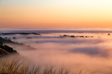 Beautiful panoramic landscape with river valley covered by thick fog in autumn in the early morning. Sunrise.の写真素材