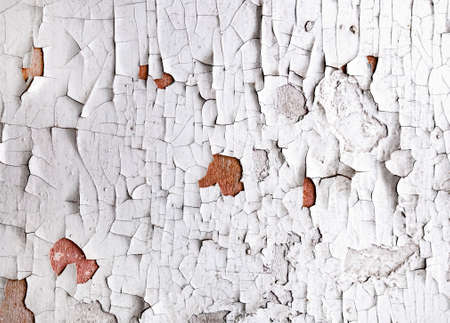 Old cracked white paint peeling off from wall texture background. Close-up detail of cracked paint.の写真素材