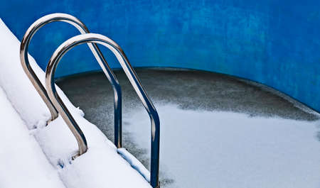 Ice swimming pool in the winter, Steps, hand-rails and garden chair in the frozen blue pool ice-holeの写真素材