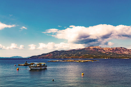 Fish farm and fisherman boat on background of Corfu island, view from Albanian coast to Corfu,...