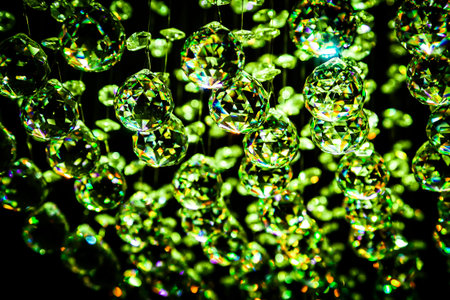 Abstract background - Christmas decoration or crystal chandelier pendant or crystal faceted balls in green tone on black.の写真素材