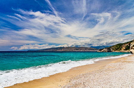 Albania, Saranda resort. View of the rocks, beach and the sea, Corfu island is on the horisont. Blue sea and sky with white clouds. Ionian Seaの写真素材
