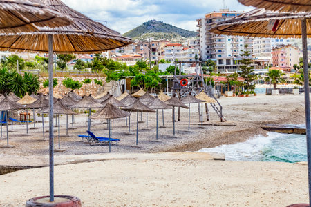 Empty beach with reed beach umbrellas, nobody on the beach. Beach with no travelers and tourists. Cancellations due to coronavirus covid-19. Quarantine.のeditorial素材