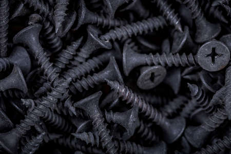 Close up of black self-tapping screws on the counter of a hardware store. background of the screws.の写真素材