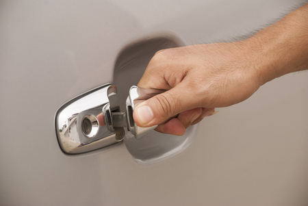 Close up of a man opening a car door in a garageの写真素材