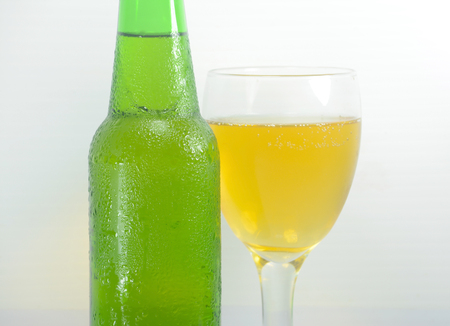 Green Bottle with Condensation and Glass of beer Isolated on white backgroundの写真素材