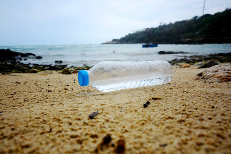 A plastic bottle floating in the sea in a beach with dirty coast